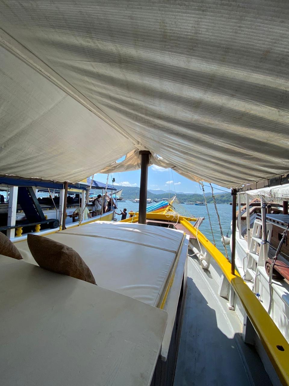 Colchões na proa sob o toldo, com vista para a baía