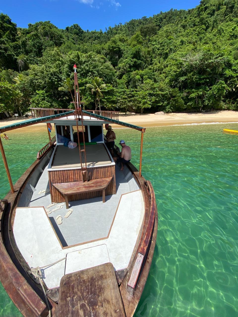 Proa do Carmen Lucia ancorado em praia de água esverdeada