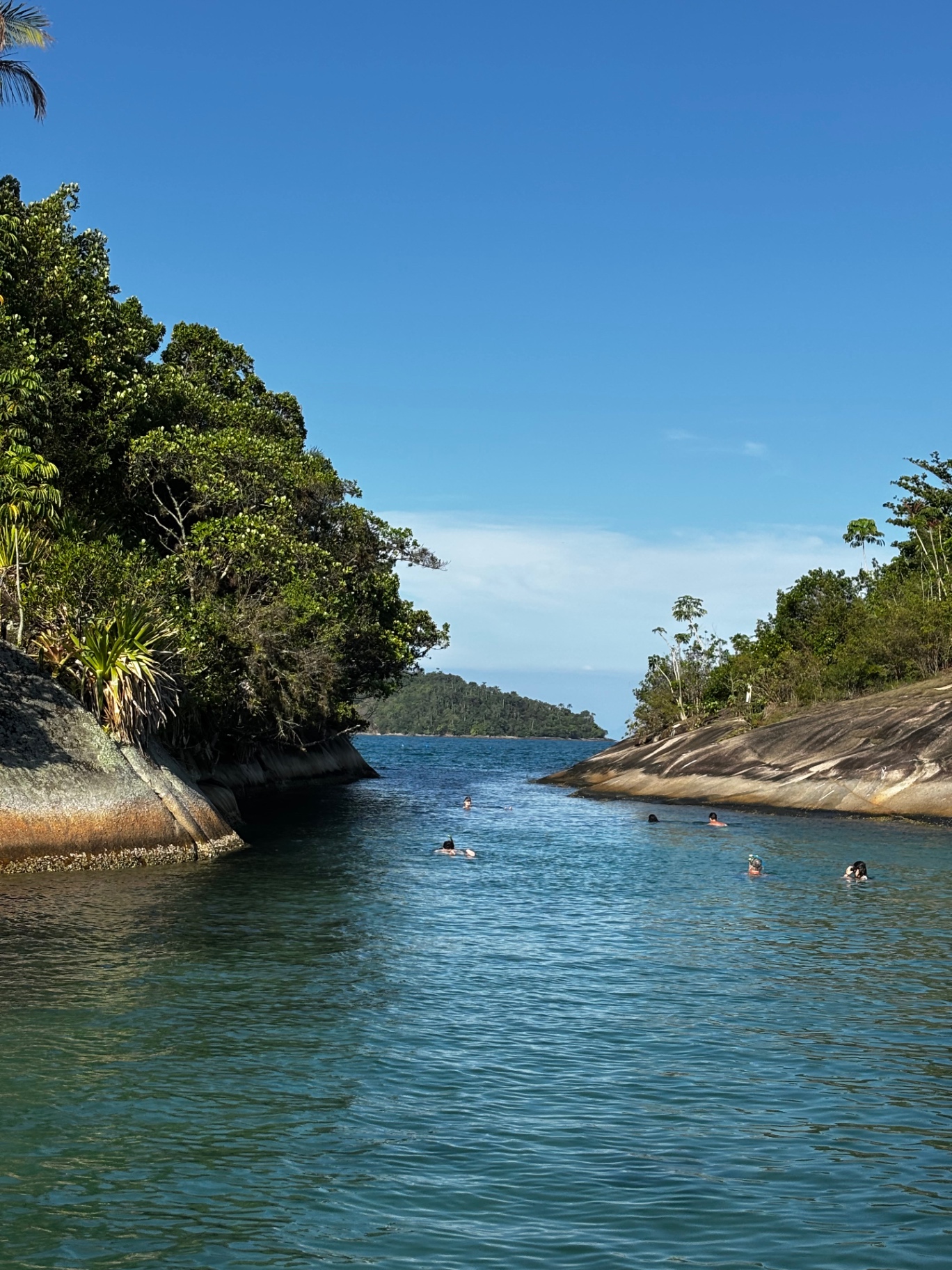 Canal entre ilhas com pessoas nadando em Paraty