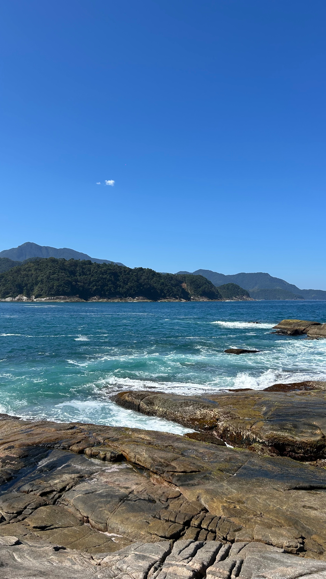 Costão de pedras e ilhas ao fundo na baía de Paraty